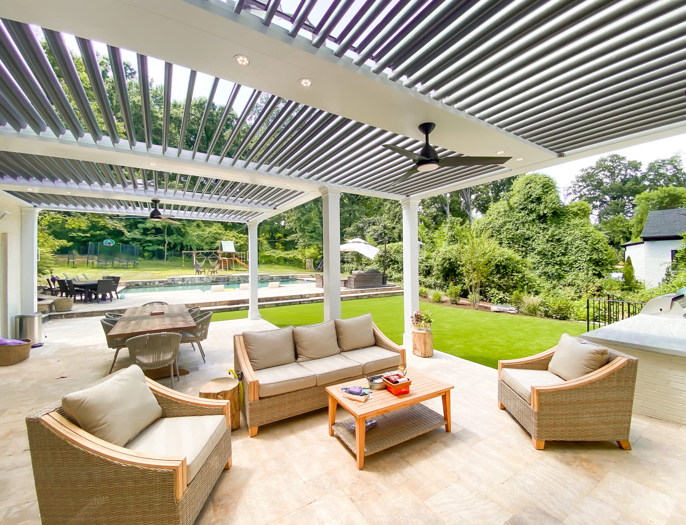 Covered backyard patio with seating and pool view