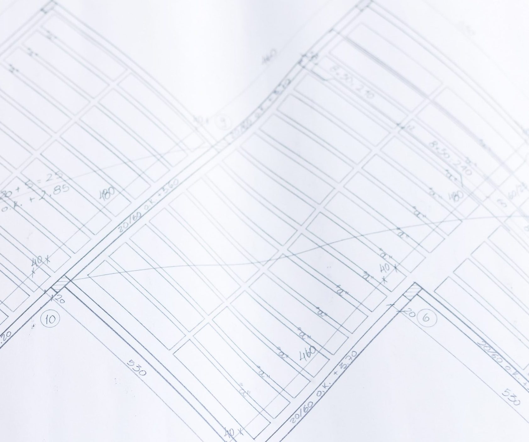 Hand holding pencil and ruler over a deck design blueprint