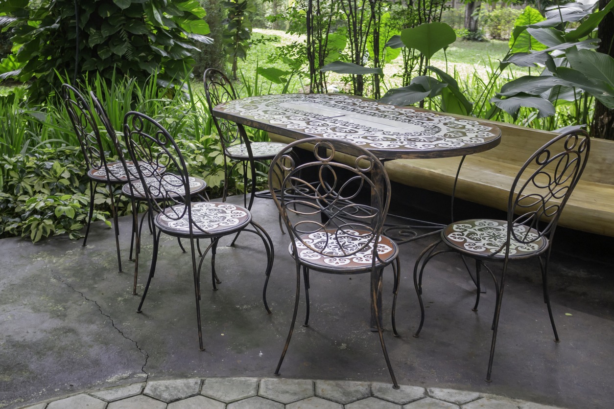 Outdoor metal table and chairs in lush garden