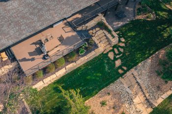 A multi-divisional project featuring deck, fencing, and landscaping. 3 different levels of green space separated by Frens Stone walls, natural stone stairs, and railing.